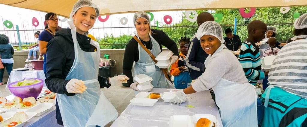 People volunteering at an outdoor food kitchen.