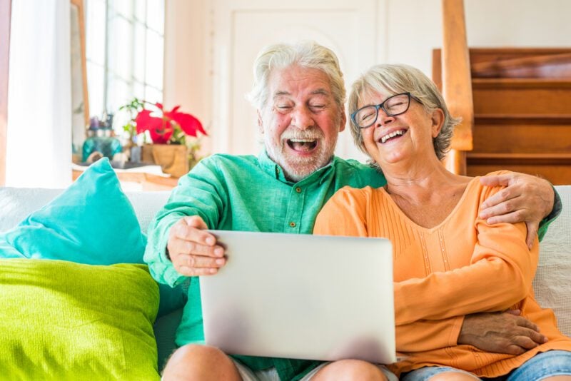 Couple laughing together on the couch.